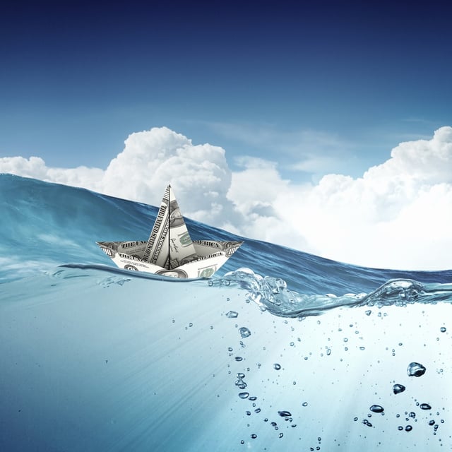 Ship made of dollar banknote floating in water.jpeg